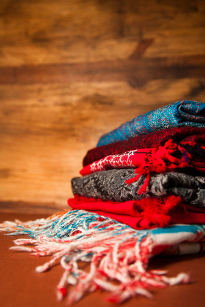 istock Stack of colorful scarves on wooden background. 699079372