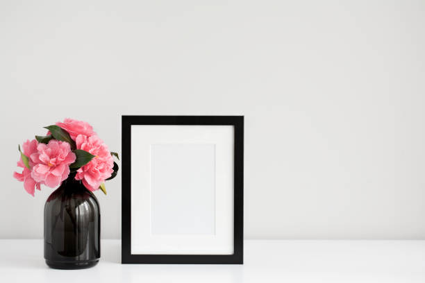 istock Mock up black photo frame with pink flowers 699086818