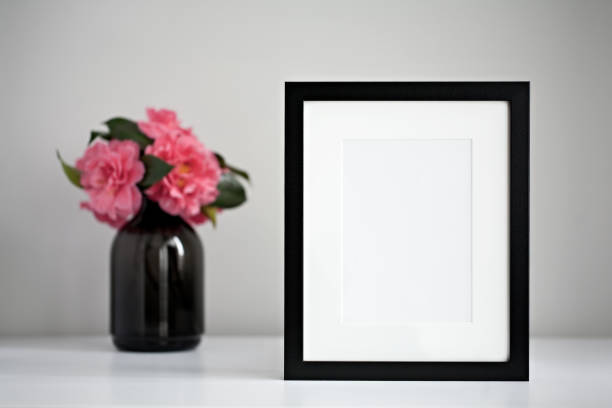 istock Mock up black photo frame with pink flowers 699087196