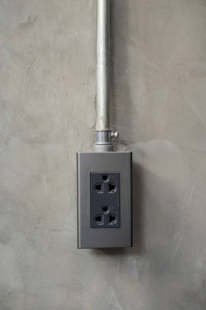 istock Electricity plug on industrial concrete wall background 699093352