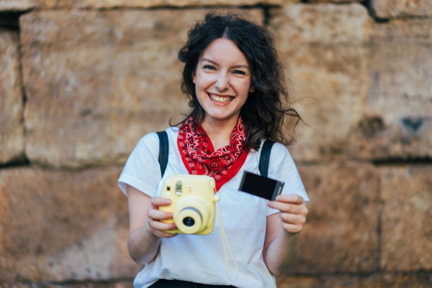 istock Young girl holding instant camera 699093552