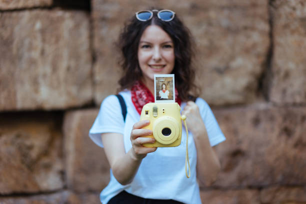 istock Young girl holding instant camera 699095616