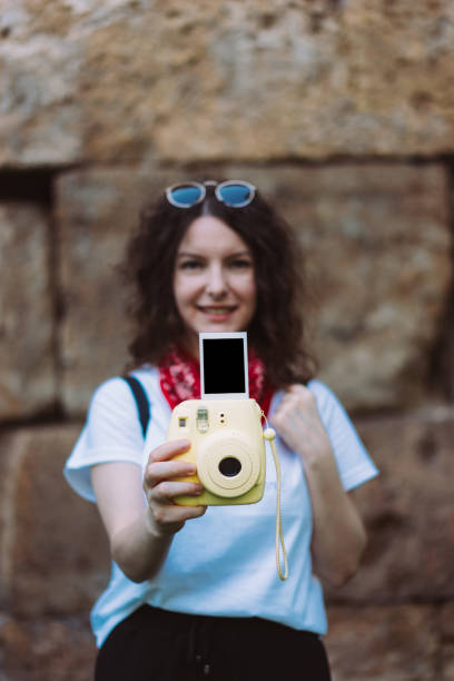 istock Young girl holding instant camera 699096288