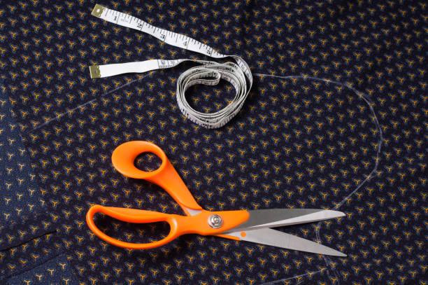 istock Scissors tailor and inch, centimeter tape on a background of blue fabric with a pattern 699097802