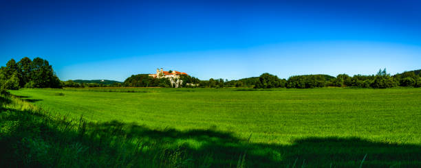 Panorama view of the Benedictine Abbey in Tyniec, in the foreground of a meadow.