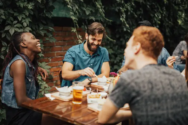 Photo of Happy multi-ethnic group of people laughing at the restaurant
