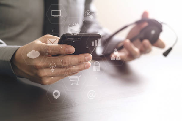 istock businessman using VOIP headset with mobile phone and concept communication call center on wooden desk 699186696