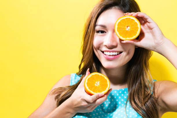 istock Happy young woman holding oranges 699187162
