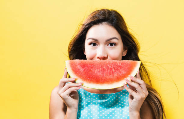 istock Happy young woman holding watermelon 699187178
