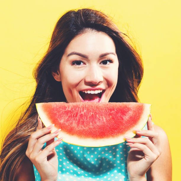 istock Happy young woman holding watermelon 699187194