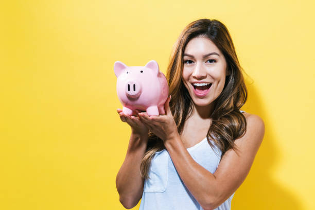 istock Young woman with a piggy bank 699187468