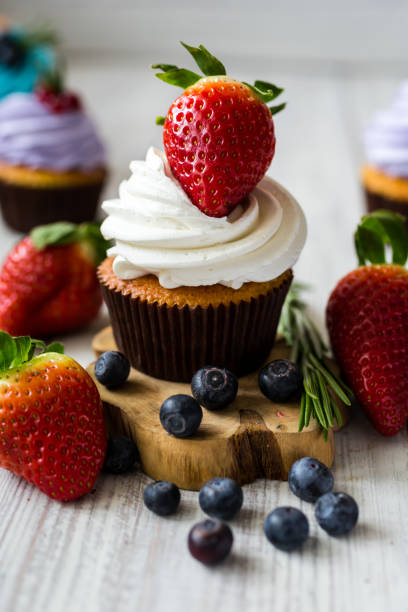 istock Chocolate cupcakes. Cupcakes. Cupcakes with berries,fruit,strawberries. Top view.colorful cupcake,tasty cake,colorful cream,cupcakes with summer berries on wooden background,close up,dessert concept 699194550