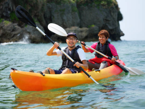 Young Japanese people enjoying an ocean kayak adventure in Okinawa, Japan.