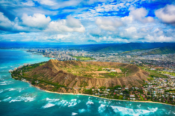 Aerial of Honolulu Hawaii Beyond Diamond Head The beautiful coastline of Honolulu Hawaii shot from an altitude of about 1000 feet during a helicopter photo flight over the Pacific Ocean with Diamond Head in the foreground. oahu stock pictures, royalty-free photos & images
