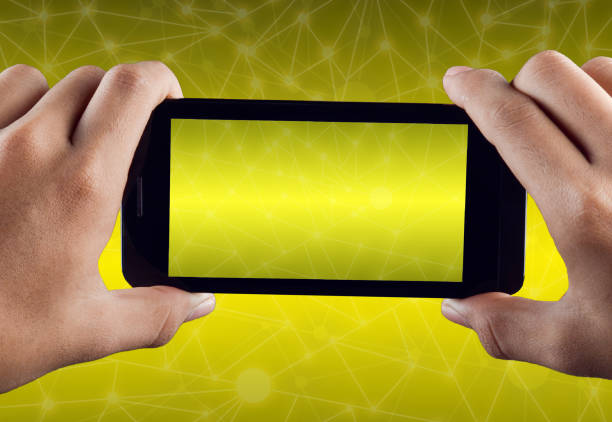 istock Hand holding smart phone over yellow abstract polygonal connecting dot technology background 699260108