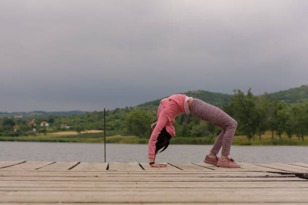 Teenage exercise gymnastics on the dock next to the lake