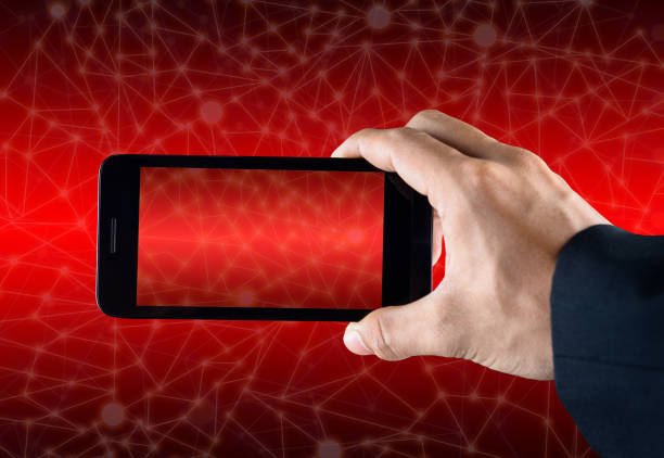 istock Hand holding smart phone over red abstract polygonal connecting dot technology background 699267972