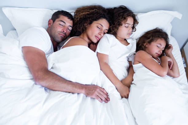istock Family sleeping together on bed 699278378