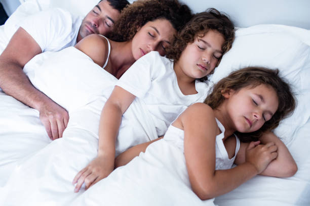 istock Family sleeping together on bed 699278424