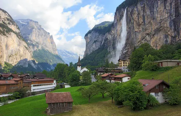 Beautiful Staubbachfall waterfall flowing down the picturesque Lauterbrunnen valley and village in Bern canton, Switzerland, Europe