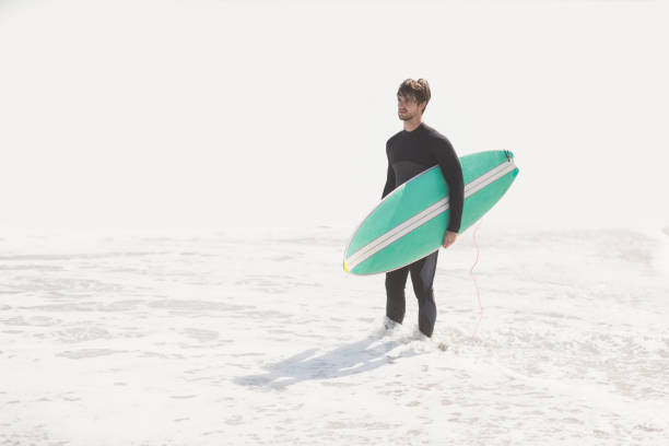 istock Man holding surfboard on the beach 699307628