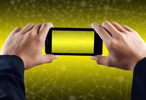 istock Hand holding smart phone over yellow abstract polygonal connecting dot technology background 699310040