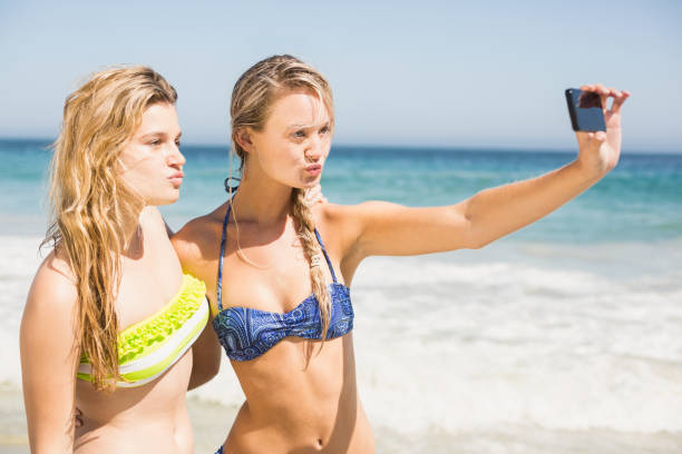 istock Two friends in bikini taking a selfie 699311160