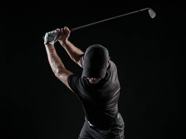 Imagem dramática de um golfista masculino no topo do seu balanço - foto de acervo