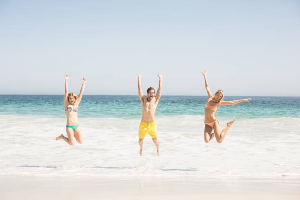 istock Happy young friends jumping on the beach 699337134