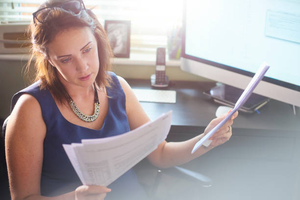 Businesswoman reads through client paperwork