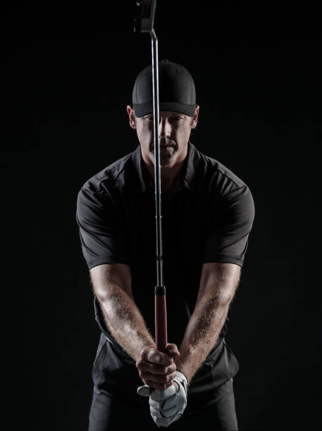 Dramatic Black and White Image Of a Male Golfer taking aim at his putt.
