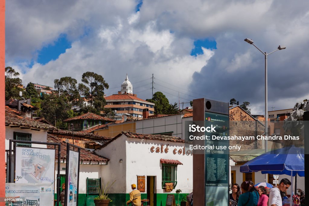 Bogotá, Colombia - The Plaza del Chorro de Quevedo in Bright Afternoon Sunlight Bogotá, Colombia - May 28, 2017: Looking towards the mountain from the Plaza del Chorro de Quevedo, the square on which the capital city of Bogotá is believed to have been established in 1538. Bright sunlight lights up the scene. The Square, which is popular with both tourists and local Colombian people, is undergoing some refurbishment; the fountain in the middle of the Square (to left of image), has been boarded off. The elevation on the Square is around 8500 feet above mean sea level. Photo shot in the afternoon sunlight; horizontal format. Camera: Canon EOS 5D MII. Lens: Canon EF 24-70 F2.8L USM. La Candelaria - Bogota Stock Photo