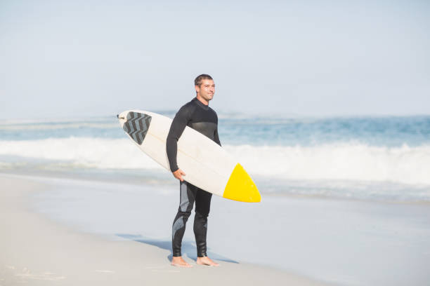 istock Surfer holding a surfboard on the beach 699368358