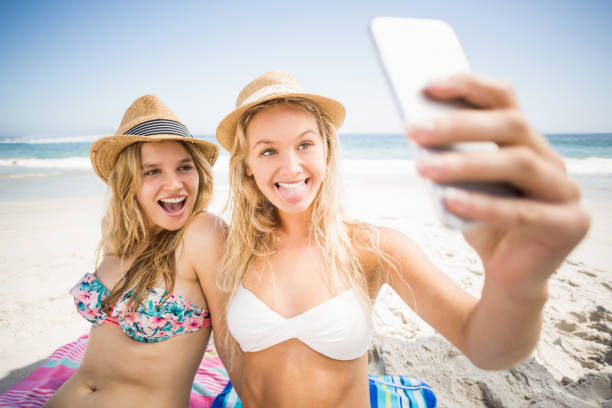 istock Two friends in bikini taking a selfie 699368584