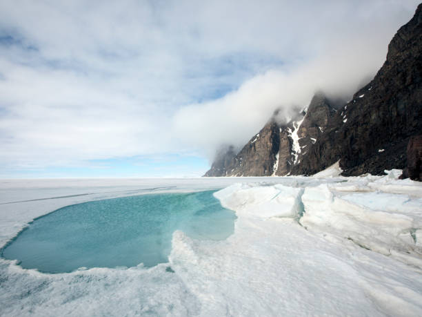 góry z dramatycznym arktycznym niebem i lodem morskim z meltwater - baffin island zdjęcia i obrazy z banku zdjęć