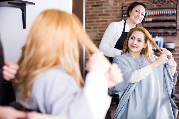 istock Glad woman decides with master how to cut hair 699516878