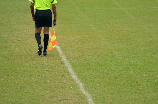 Soccer assistant referee is running along side line