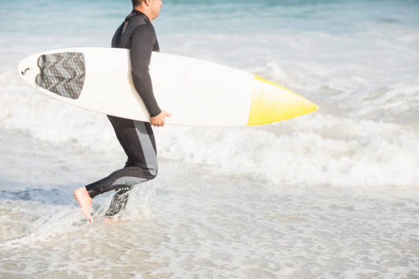 istock Surfer walking on the beach with a surfboard 699592652