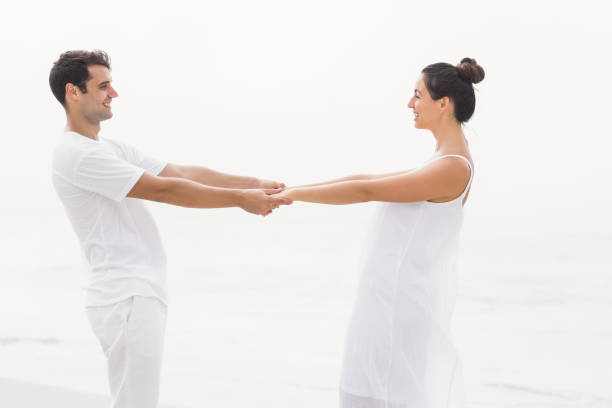 istock Romantic couple holding hands on the beach 699593520