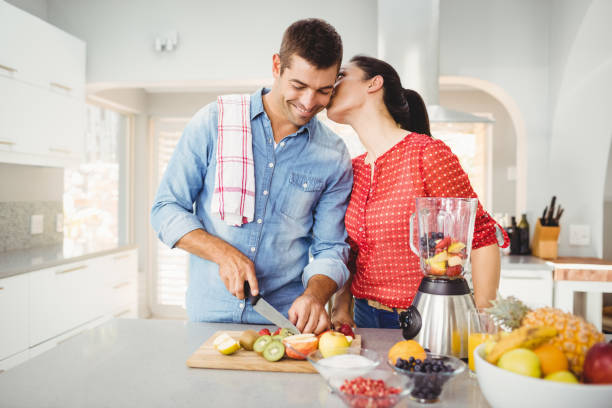 istock Woman kissing man preparing fruit juice 699597340
