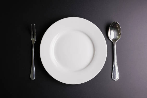 istock White dish, Spoon and fork isolated on black background with copy space image for your text. 699602326