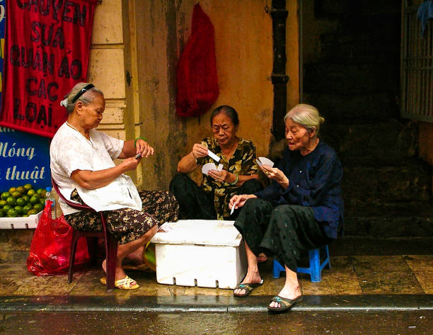 Three elderly Vietnamese women play cards in the Old Quarter of Hanoi, Vietnam