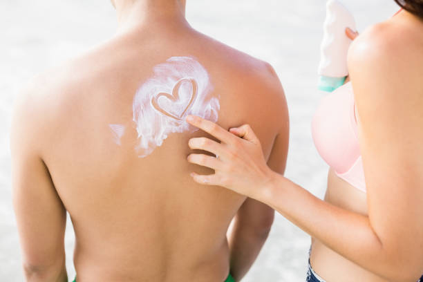 istock Woman making a heart symbol on mans back while applying a sunscreen lotion 699635874