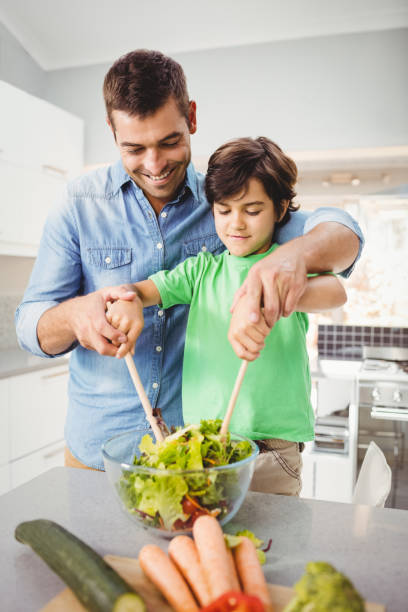 istock Happy father and son preparing salad 699651022