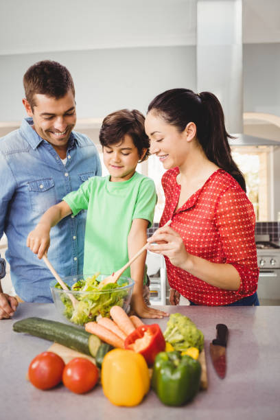 istock Happy parents and son preparing salad 699651134