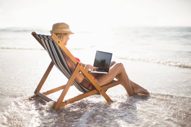 istock Woman sitting on a armchair and using a laptop 699676546