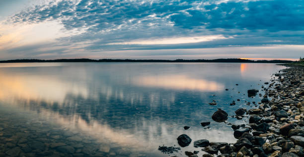 istock Seascape panorama with calm water and scenic clouds 699702346
