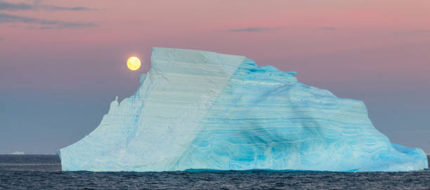 Antartic Moonrise over the Weddell Sea The Full Moon is rising over the iceberg filled Weddell Sea. Antarctica. iceberg dramatic sky wintry landscape mountain stock pictures, royalty-free photos & images