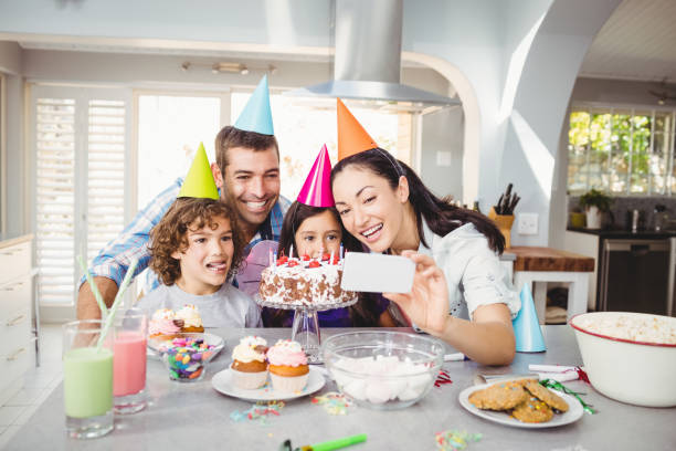 istock Family smiling while taking selfie during birthday celebration 699712360