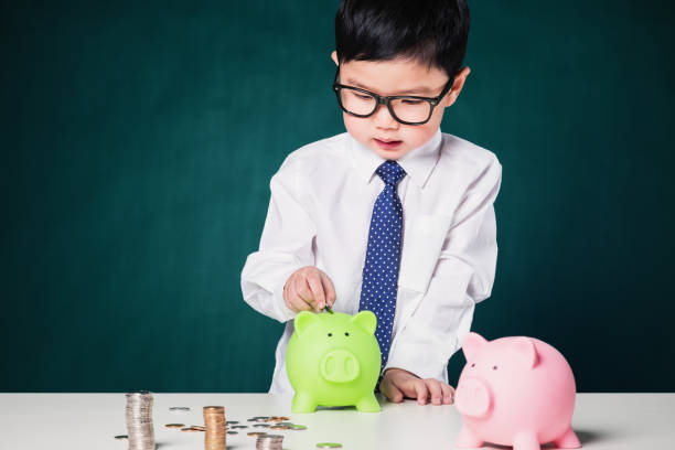 istock Cute business boy with a stack of coins 699712496